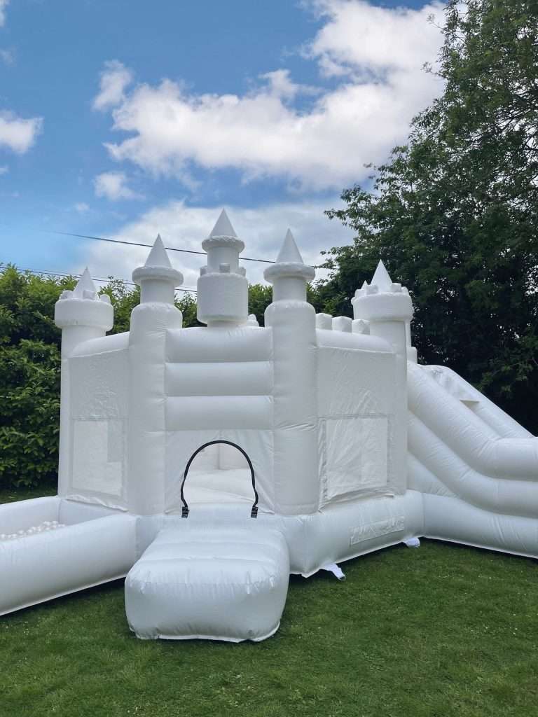 WHITE BOUNCY CASTLE WITH SLIDE AND BALL PIT. THEMED LIKE A PRINCESS CASTLE